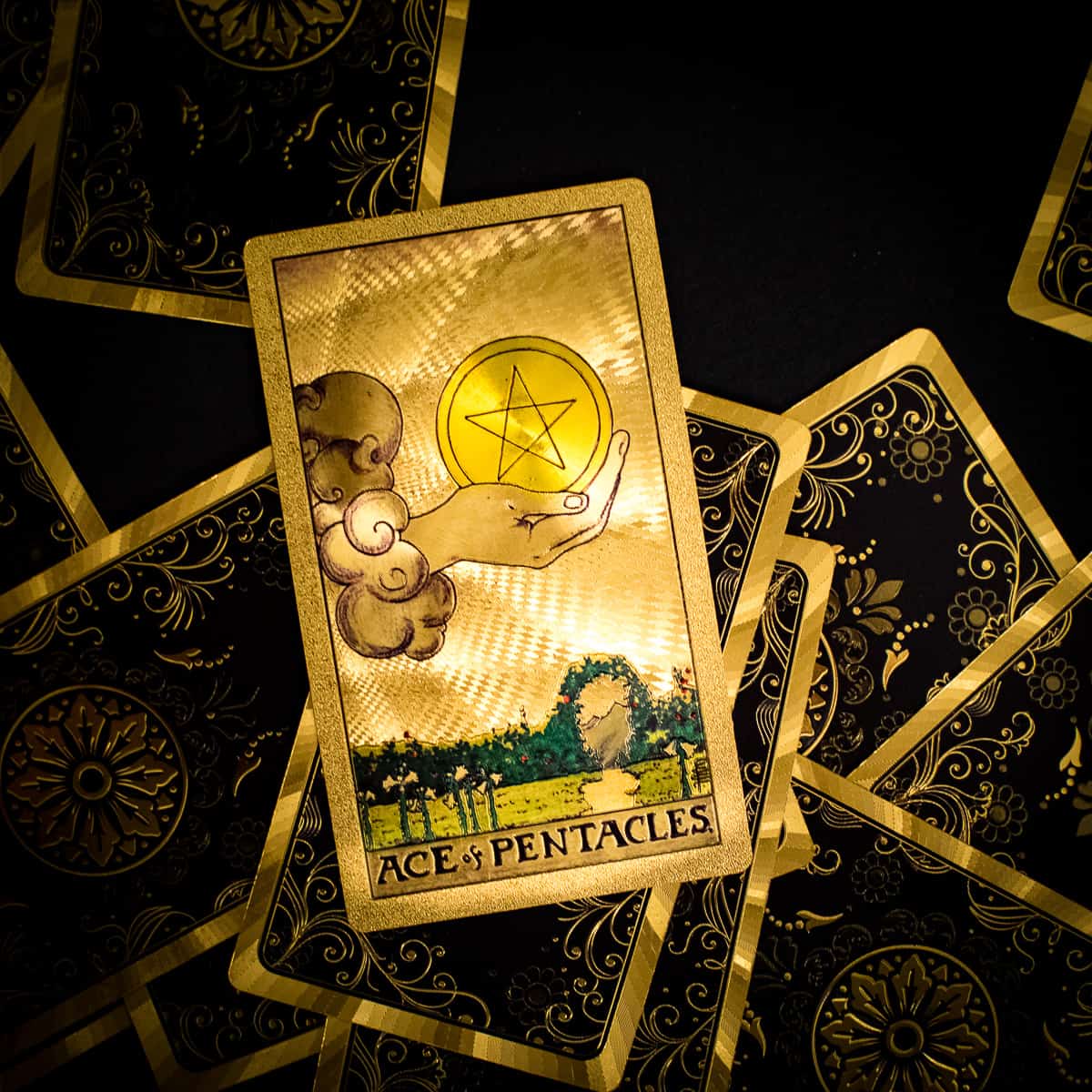 The Ace of Pentacles card from the deck of tarot depicting a large hand emerging from the clouds holding a single pentacle. 