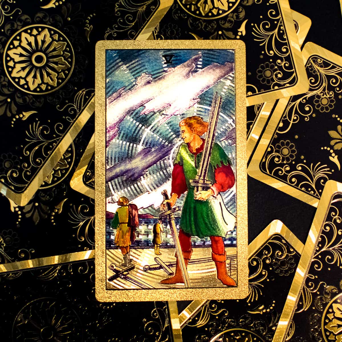 The five of swords tarot card on a deck.