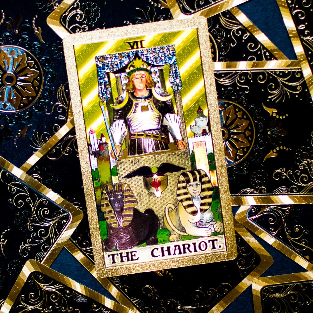 The Chariot card in the deck of tarot on a pile of tarot cards.