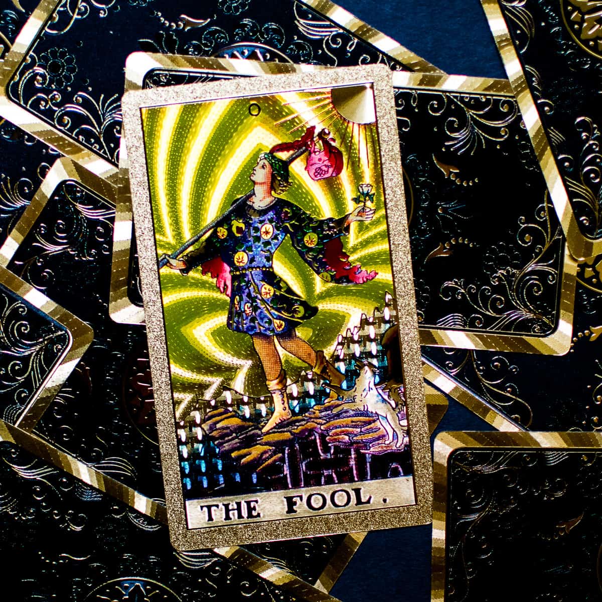 An image of The Fool on a tarot card on top of a deck. 
