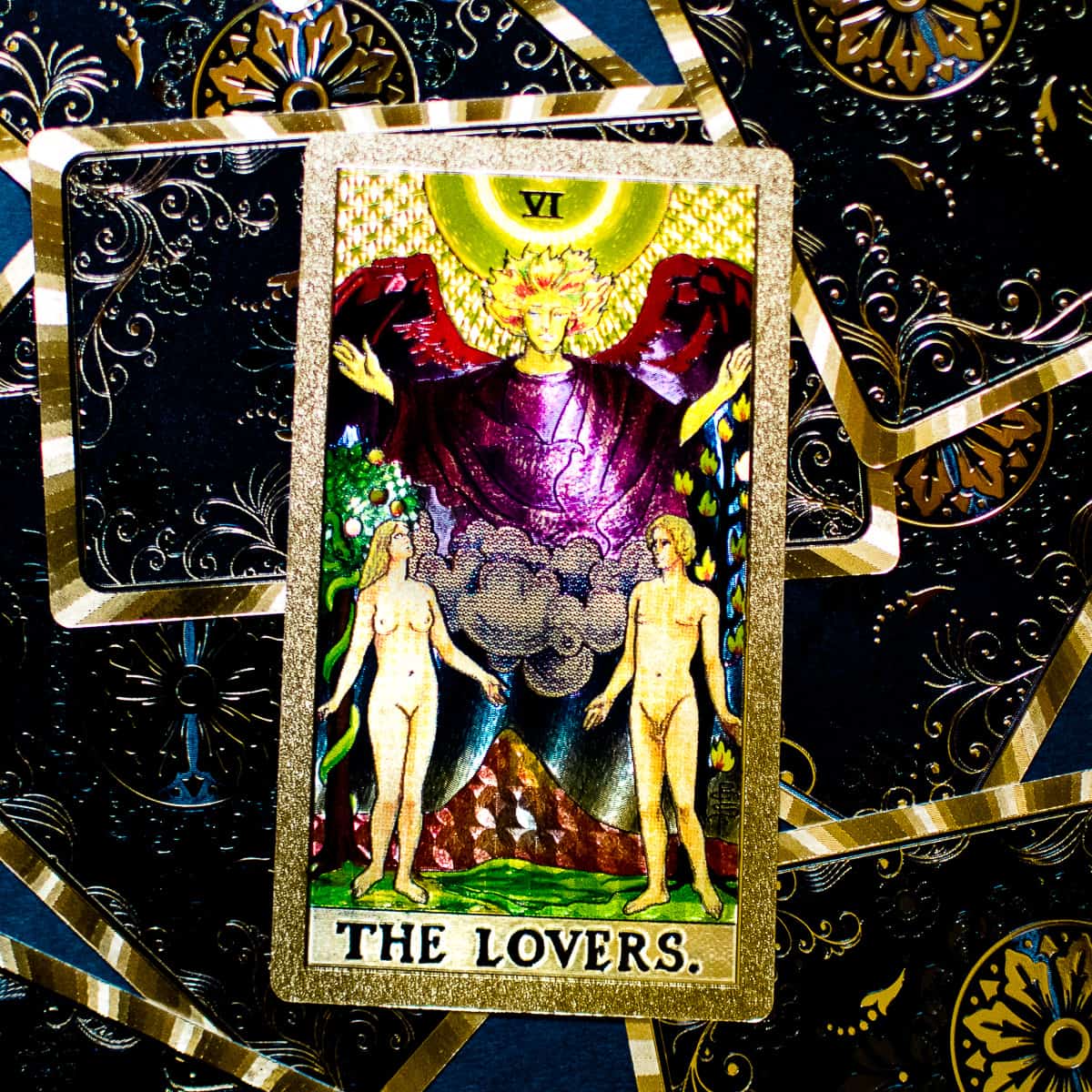 The Lovers tarot card sitting on a pile of cards. 