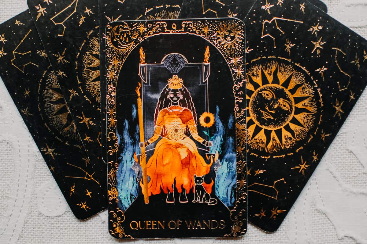 The Queen of Wands card on top of the Dreamy Moons tarot deck. 