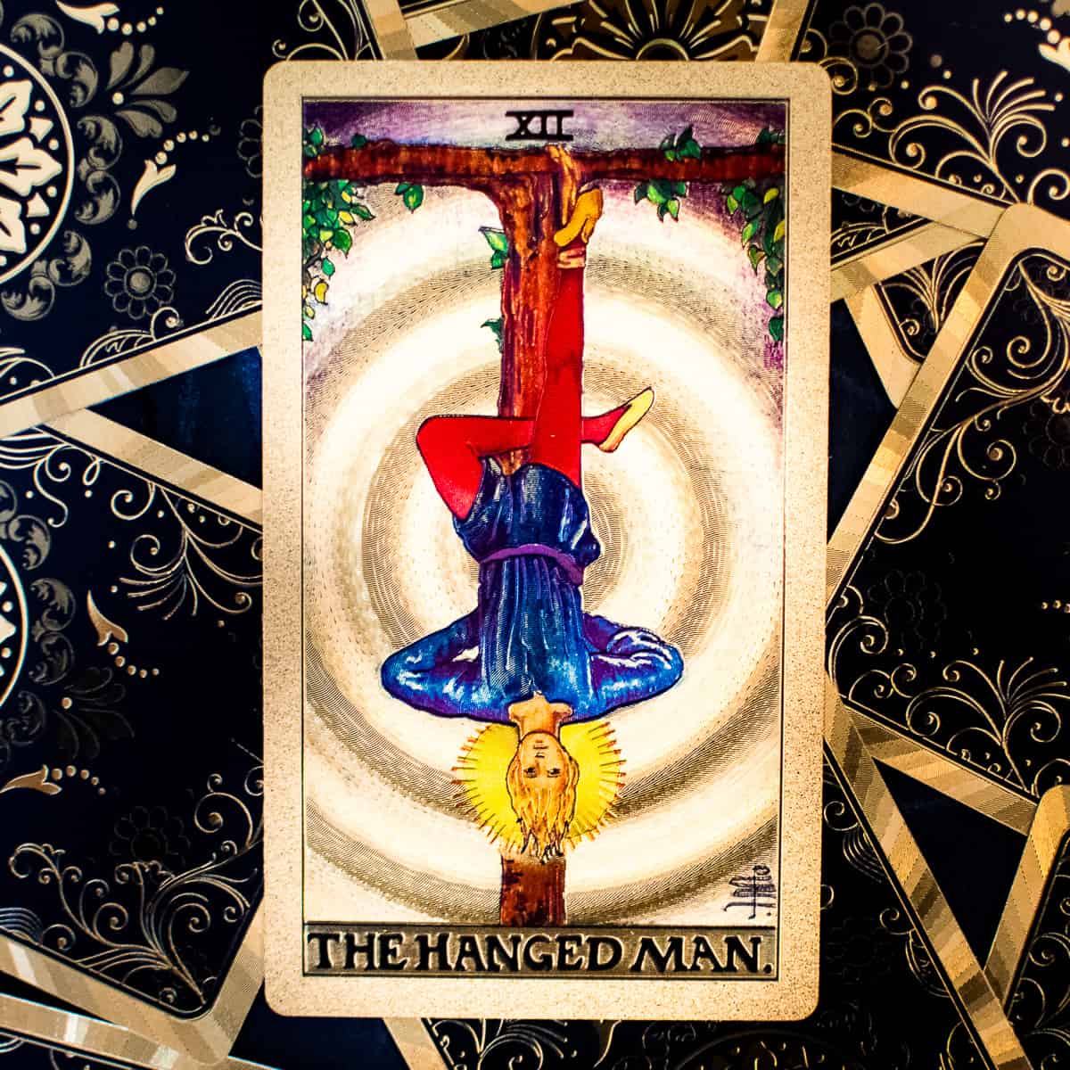 The Hanged Man tarot card depicts a man suspended upside down from a tree branch by his foot. 