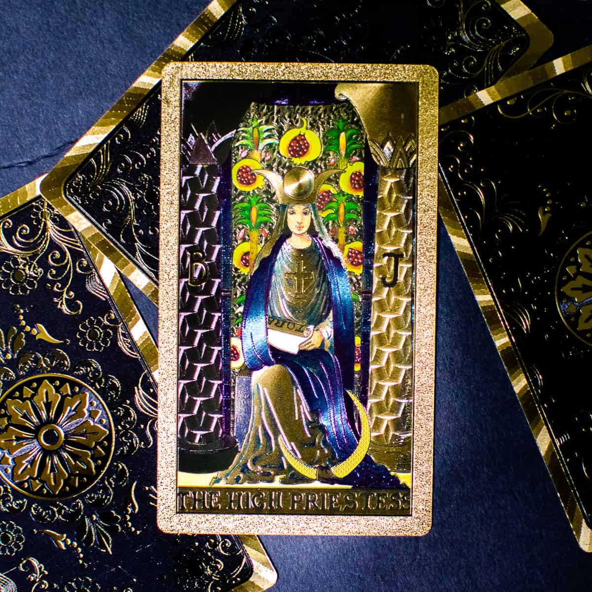 The High Priestess sitting between two pillars depicted on a tarot card. 
