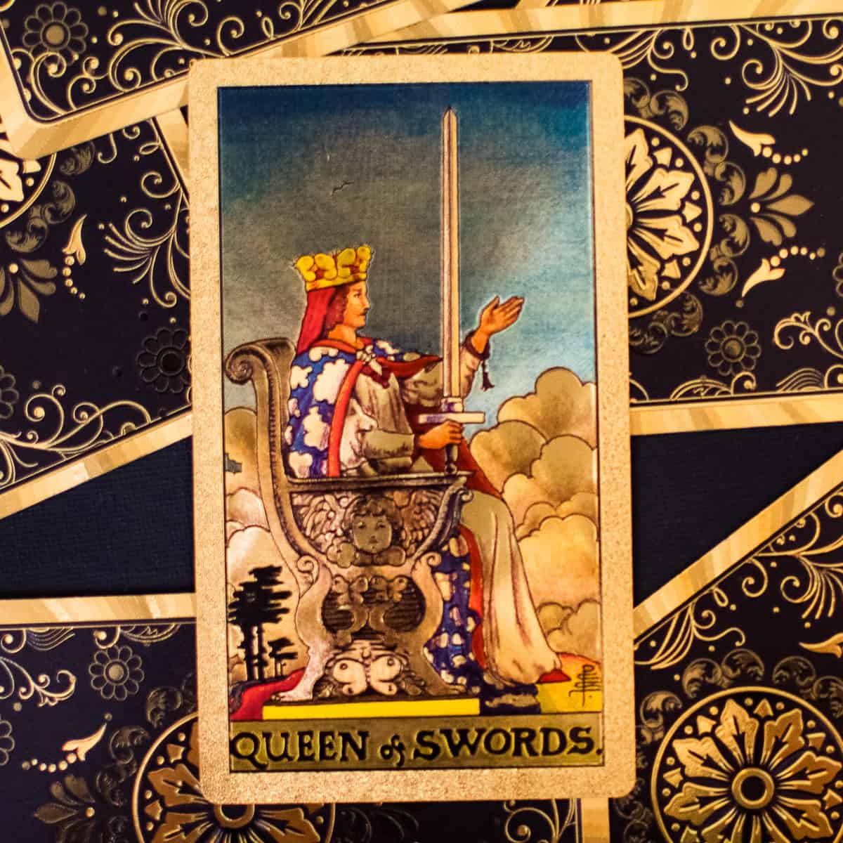 Queen on throne with a sword on a tarot card.