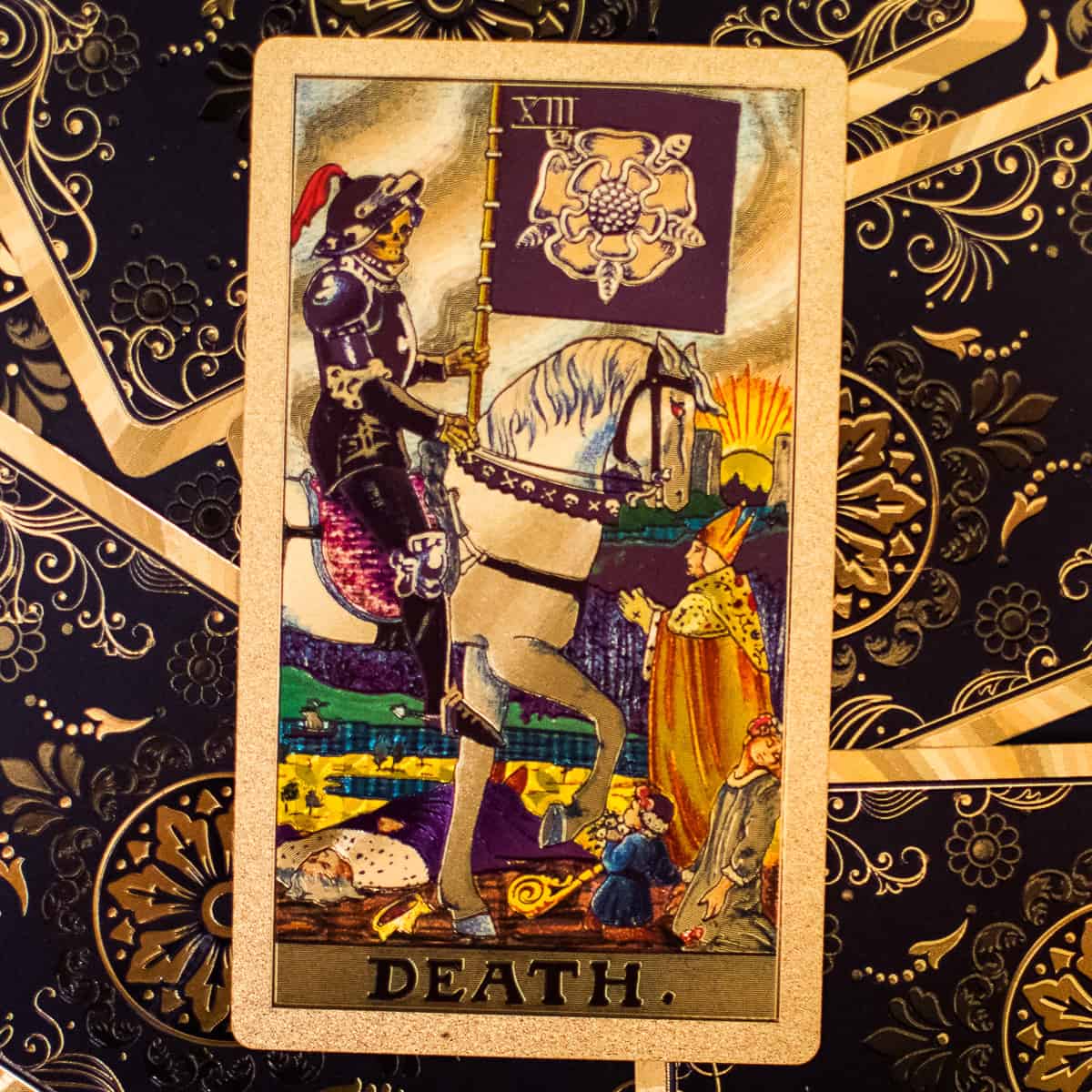 The figure known as Death, riding a horse with people at the ground depicted on a tarot card.