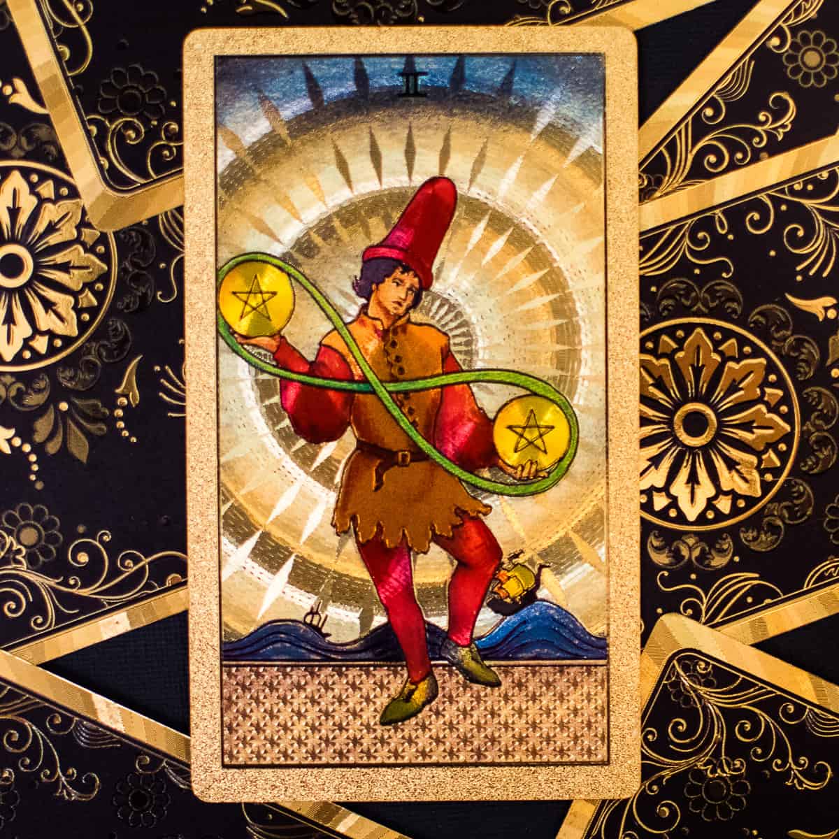 A person juggling two pentacles on a tarot card.