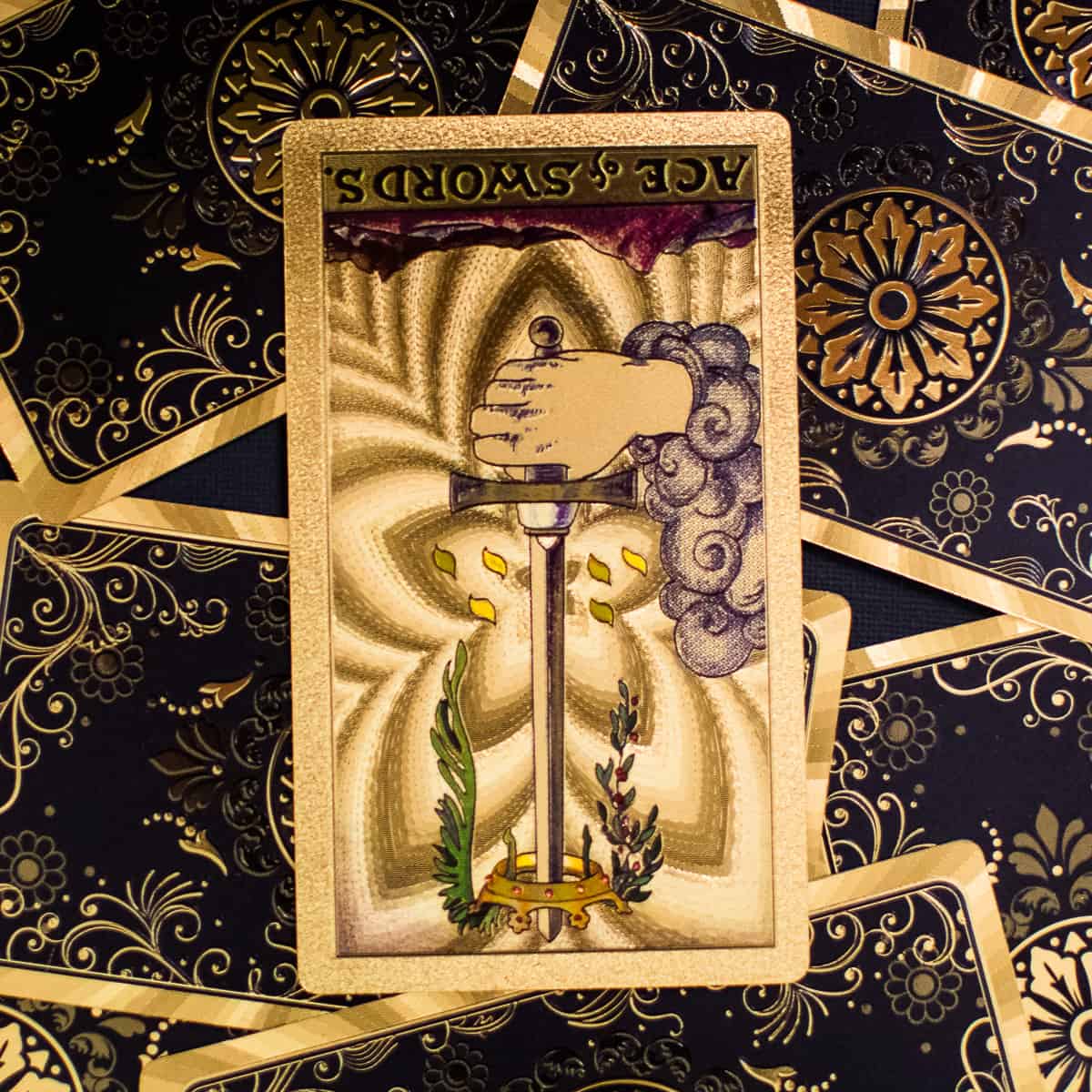 Ace of Swords tarot card shown in the reverse position depicting a single hand and sword emerging from a cloud.