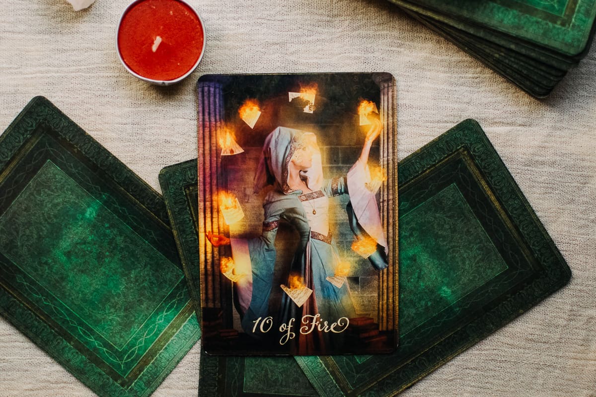 The 10 of Fire card showing a woman surrounded by 10 glowing lanterns.