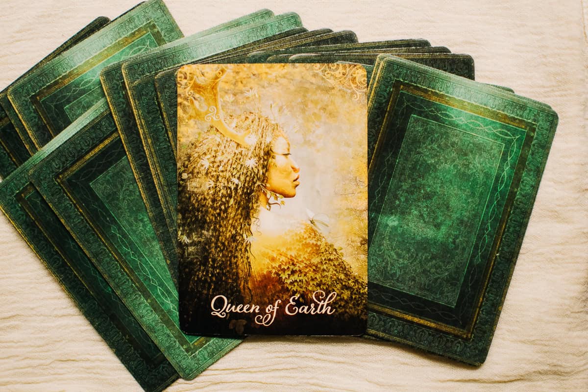 The Queen of Earth tarot card as a person on top of a deck. 