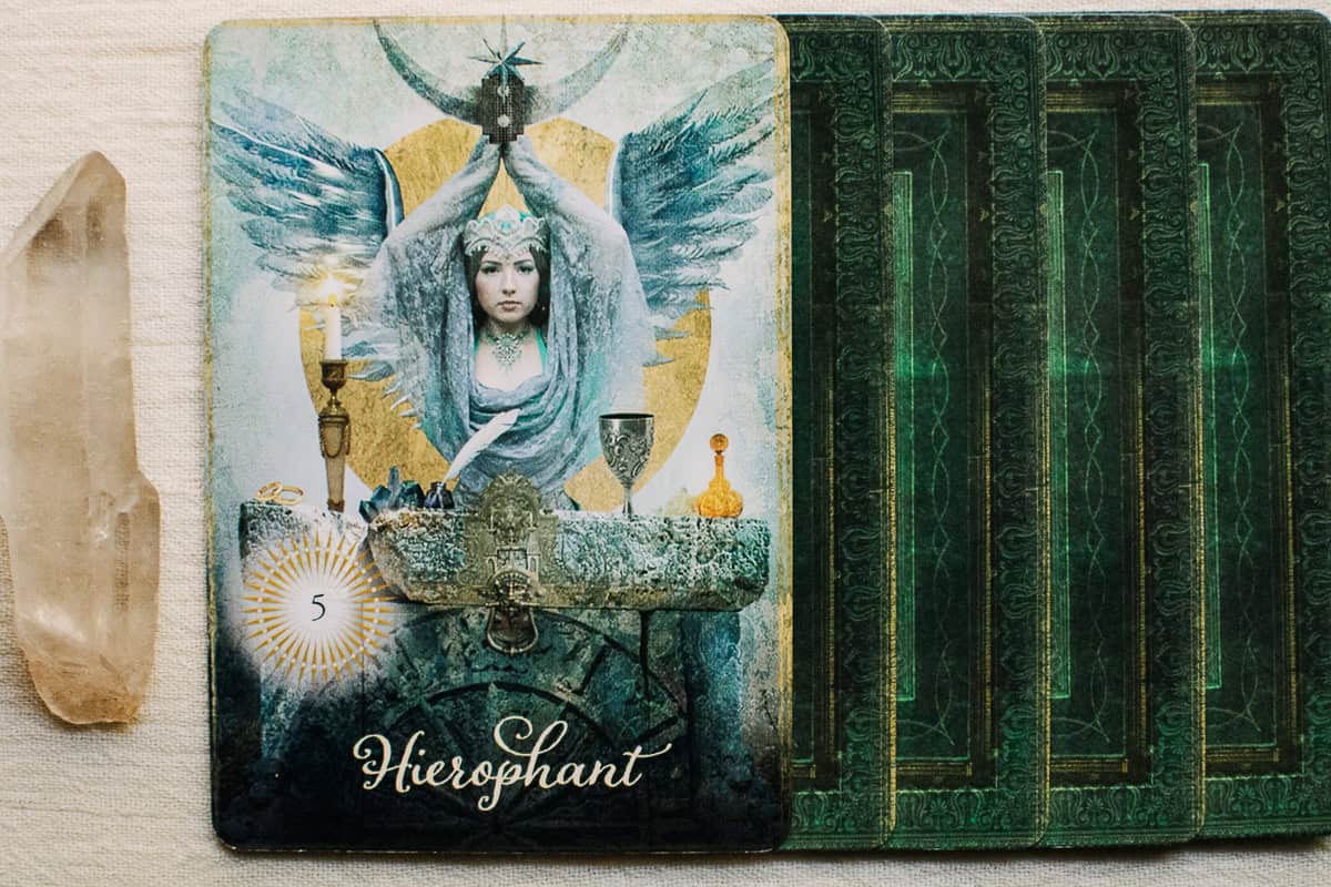 The Hierophant tarot card on a deck of green cards.